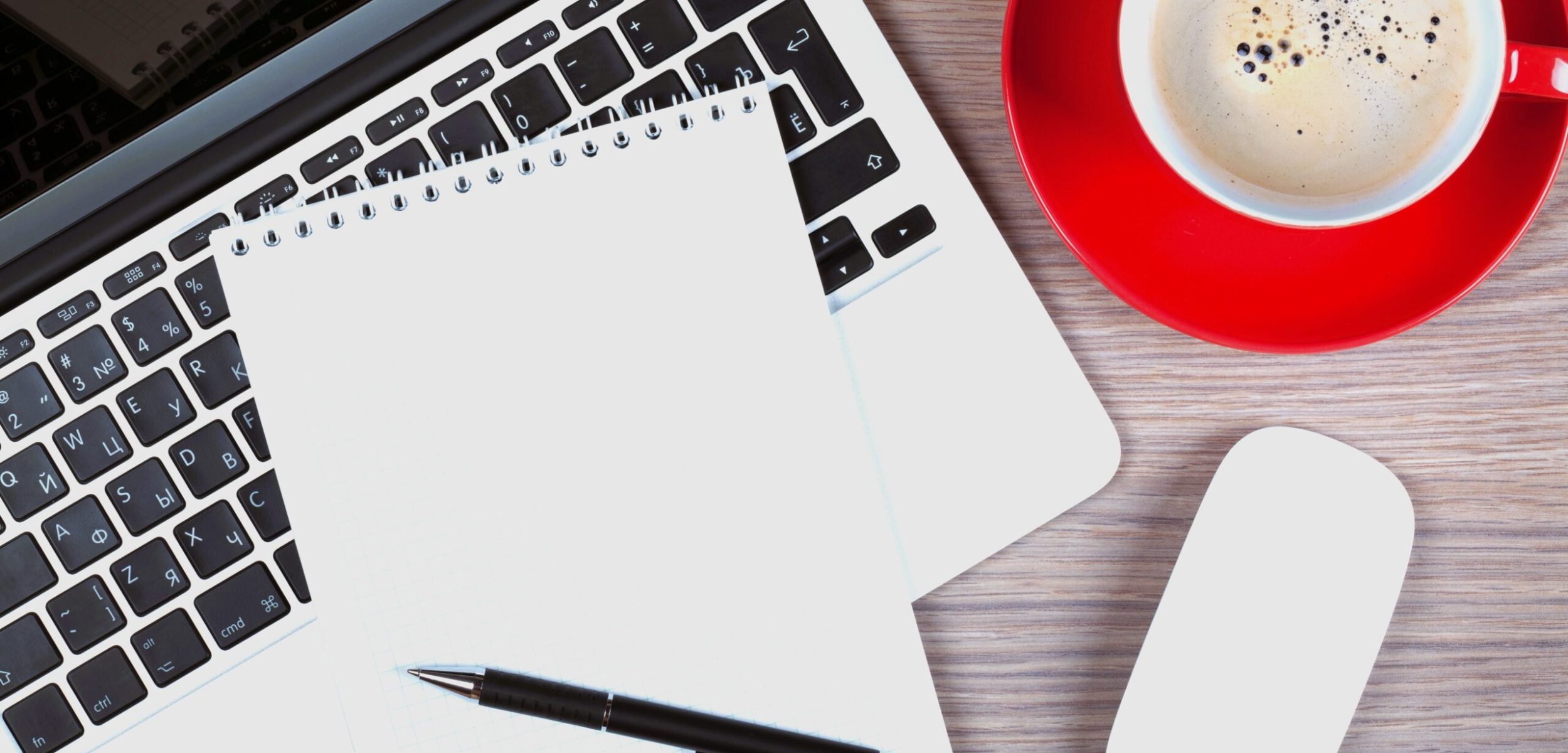 Blank notepad over laptop and coffee cup